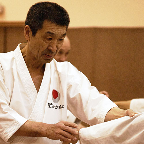 Le Maître Yoshiharu Osaka Sensei, expert mondial de la JKA, en keikogi blanc au dojo.