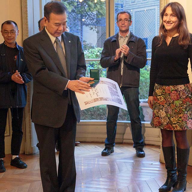 Remise de distinction officielle à Ueki Shihan en costume par les représentants de la mairie à Paris, en présence des membres du club.